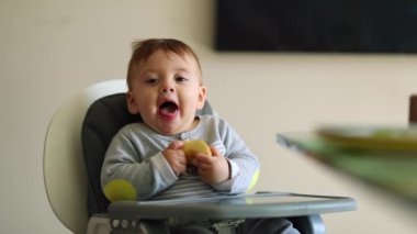Baby gagging while eating piece of apple open mouth