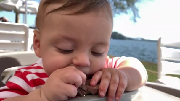 Baby Toddler Boy Eating Meat Lunch Outdoors — Vídeo de stock