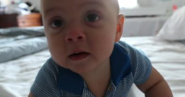 Baby toddler lifting head toward camera smiling