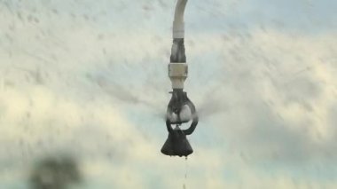 Pivot irrigation system. 120fps slow-motion close-up of pivot sprinkler system irrigating crops. Irrigation pivot system watering agriculture field