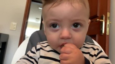 Adorable baby boy infant eating chewing happy