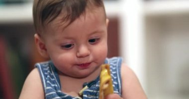 Cute toddler baby eating banana