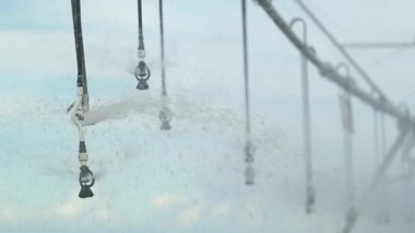 Pivot irrigation system. 120fps slow-motion close-up of pivot sprinkler system irrigating crops. Irrigation pivot system watering agriculture field