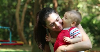 Casual interaction between mother and baby infant son relationship outside smiling and happy
