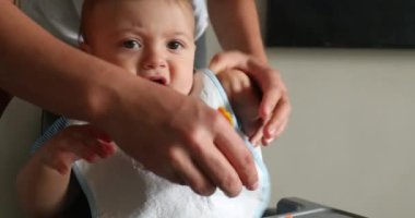 Casual home scene of baby toddler seated ready to eat meal