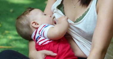 Mom breastfeeding baby infant boy outside naturally