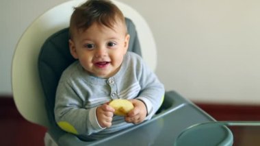 Happy Cute adorable baby boy infant on highchair looking to camera smiling