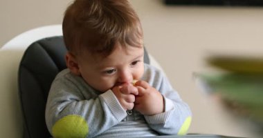 Cute baby infant taking a bite of apple fruit