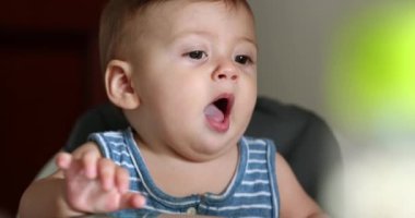 Cute baby infant boy interaction on highchair