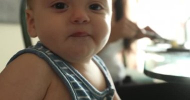 Toddler baby boy on highchair casual baby infant family scene