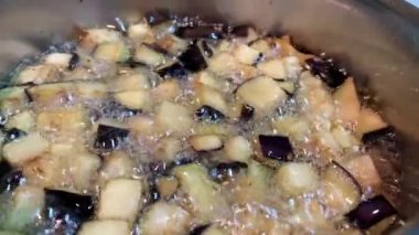 Boiling eggplant vegetable on pot cooking food closeup of red tomato sauce