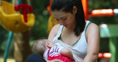 Mom breastfeeding baby infant boy outside naturally