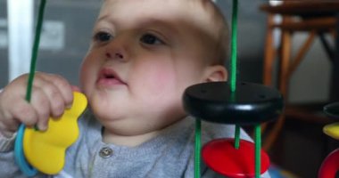 Baby toddler putting toy in mouth discovering the world