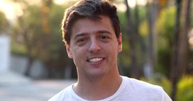 Dışarıdaki kameraya gülümseyen genç adamın mutlu portresi.