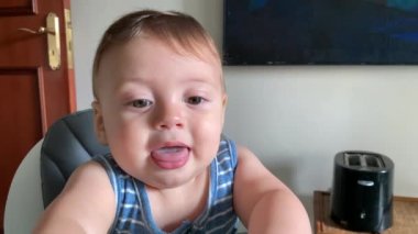 Portrait baby boy at meal table with hands on top of glass table