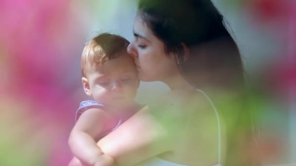 Candid Mom Holding Baby Son Dreamy Flower Colorful Foreground — Wideo stockowe