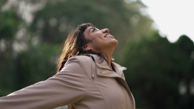 Mutlu, mutlu, İspanyol bir kadın gökyüzüne bakıyor ve kendini iyi hissediyor. Güney Amerikalı kız hayatı kutluyor