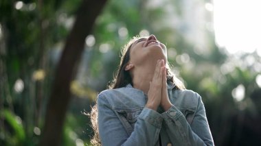 Happy woman being thankful. Spiritual girl praying looking at SKY with HOPE