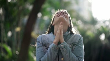 Happy woman being thankful. Spiritual girl praying looking at SKY with HOPE