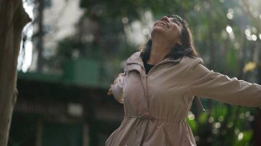 Kollarını havaya kaldırıp hayatı kutlayan mutlu bir İspanyol kadın. Neşeli bir Güney Amerikalı. Mutluluk kavramı