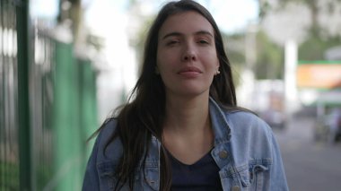 Kendine güveni tam mutlu bir kadın caddede kameraya bakarak yürüyor. 30 'ların portresi olan biri kaldırımda yürür.