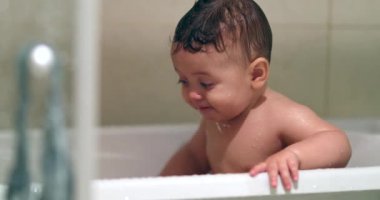 Adorable baby infant inside bathtub playing