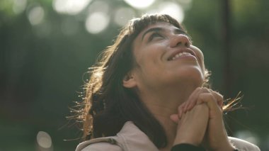 Minnettar bir kadın Tanrı 'ya dua ediyor. Gökyüzüne gülümseyen ruhani kız