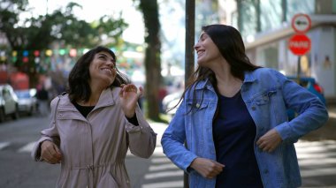 Şehir caddesinde hayatı kutlayan iki mutlu bayan arkadaş. Mutlu kadın dansçılar