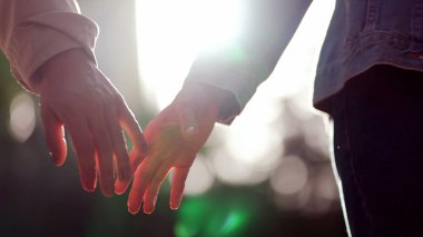 Arka planda güneş ışığının parlamasıyla ellerin birleşmesi. İki insan arasında güzel bir arkadaşlık anı.