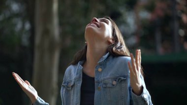 Ruhsal kadın özgürlüğü hissediyor. Kollarını açıp parkta ilahi bir duruşun varlığını hisseden kişi.