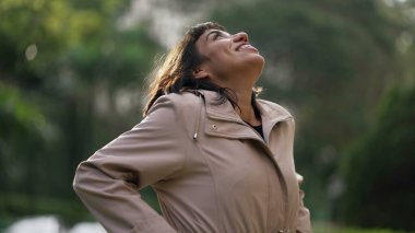 Mutlu, mutlu, İspanyol bir kadın gökyüzüne bakıyor ve kendini iyi hissediyor. Güney Amerikalı kız hayatı kutluyor