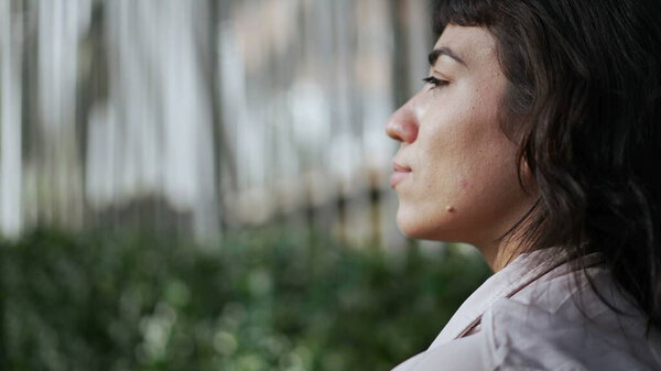 Back of a latin hispanic girl walking in street. Young woman walks forward in sidewalk