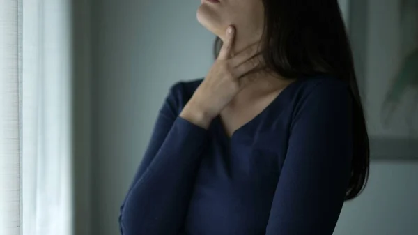 Worried Woman Standing Window Touching Her Neck Chest Seeking Comfort — Stockfoto