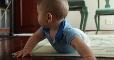 Happy baby toddler infant looking to camera smiling, crawling on floor at home