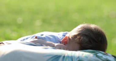 Baby and mother together laid on grass outside at park smiling relationship