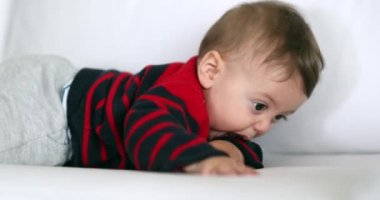Baby infant learning to crawl, effortful child crawling in first months of life
