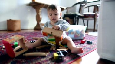 Authentic baby toddler playing with toys in room