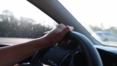 Hand holding steering wheel driving close-up