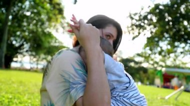 Authentic mother and baby child together at park