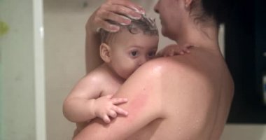Washing baby toddler in shower with mother, shampooing child hair candid and authentic