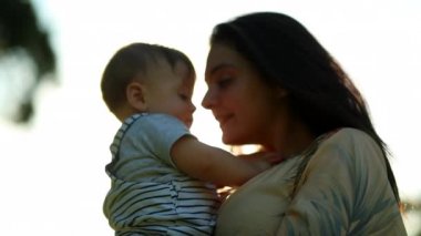 Authentic family moment mother and child baby together during sunset