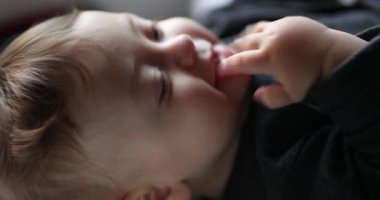 Happy joyful baby toddler doing sounds with hand in mouth