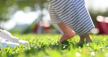 Baby toddler learning to walk outdoors, baby steps outside footsteps barefoot