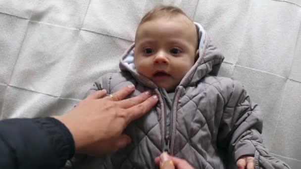 Parent Unzipping Baby Winter Clothes Arriving Home Lying Bed — Vídeo de Stock