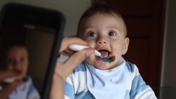 Mother Feeding Baby While Holding Smartphone Filming — Vídeo de Stock