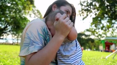 Authentic mother and baby toddler infant boy together in outdoor park