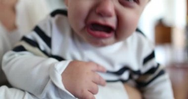 Upset angry baby toddler. Tearful infant boy crying