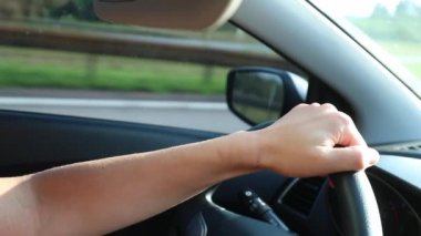 Woman holding steering wheel driving on road