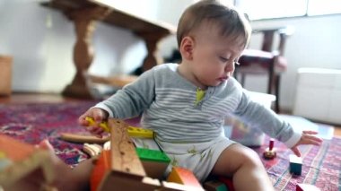 Baby toddler playing with toys at home by himself