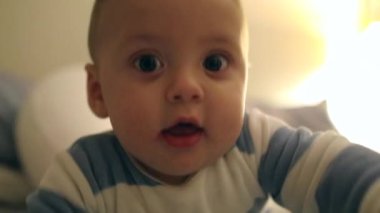Curious adorable baby toddler face looking directly to camera wanting to touch viewer